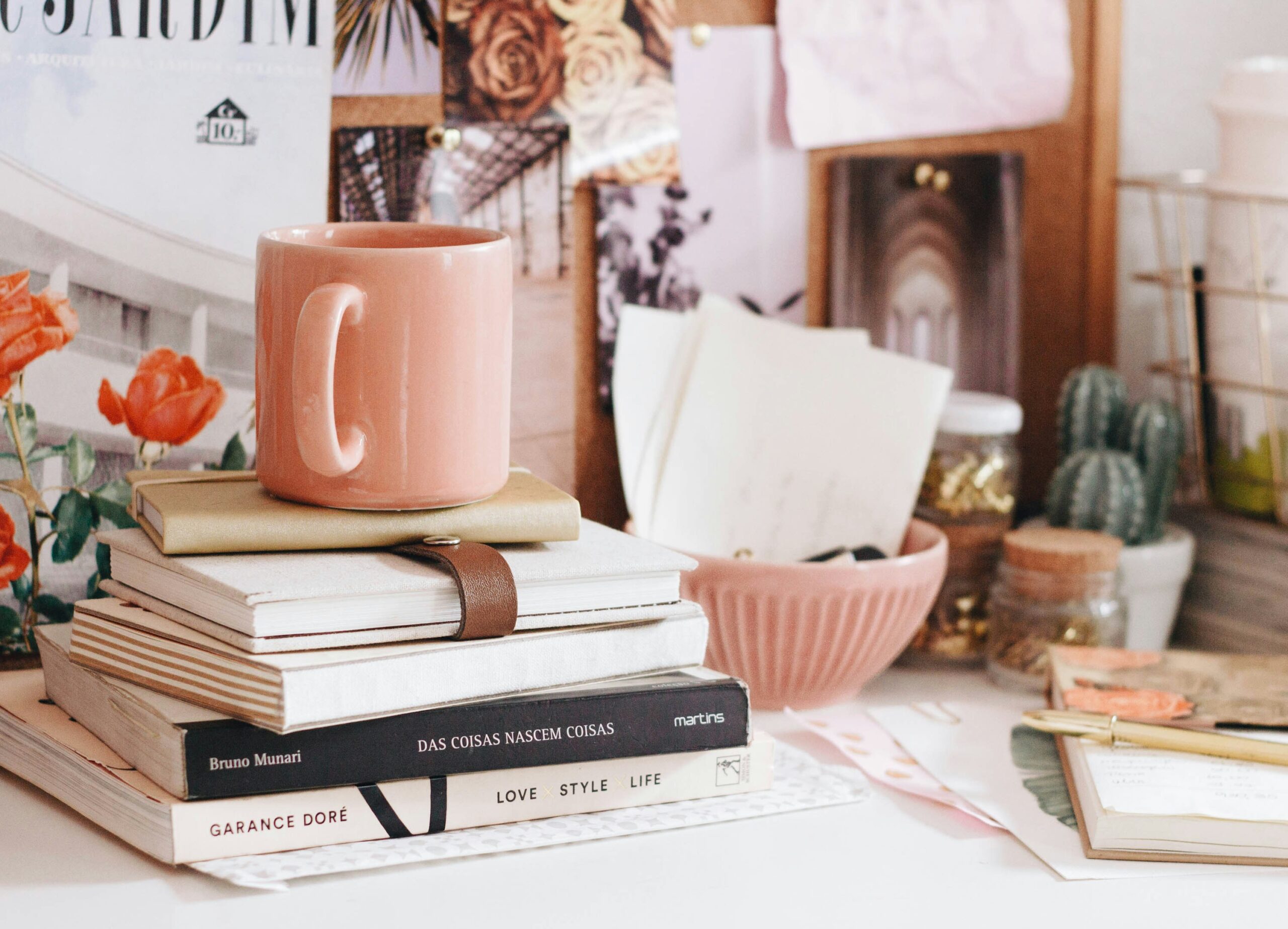 stack of books with coffee cup on desk